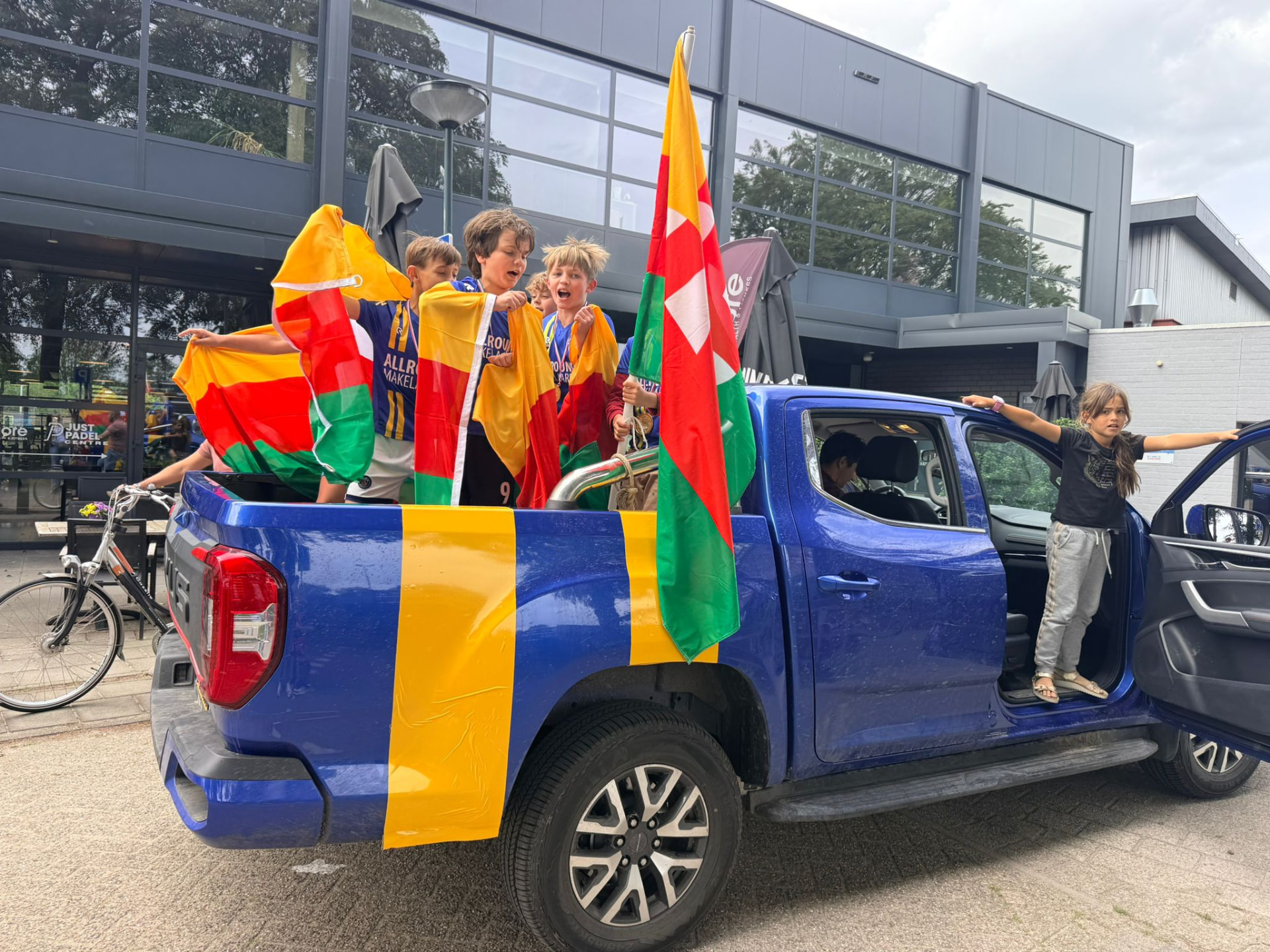 Spelers van Audacia JO-09-01 met clubvlaggen tijdens het huldigingsrondje in de Audacia pick-up